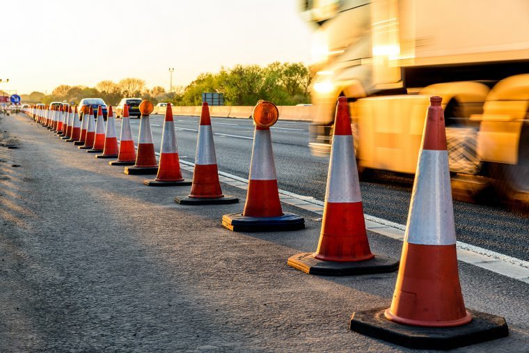 Traffic cones lining a motorway at golden hour