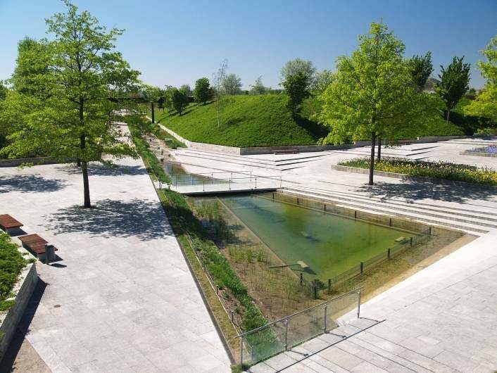 Landscaped public space with water basin and paving